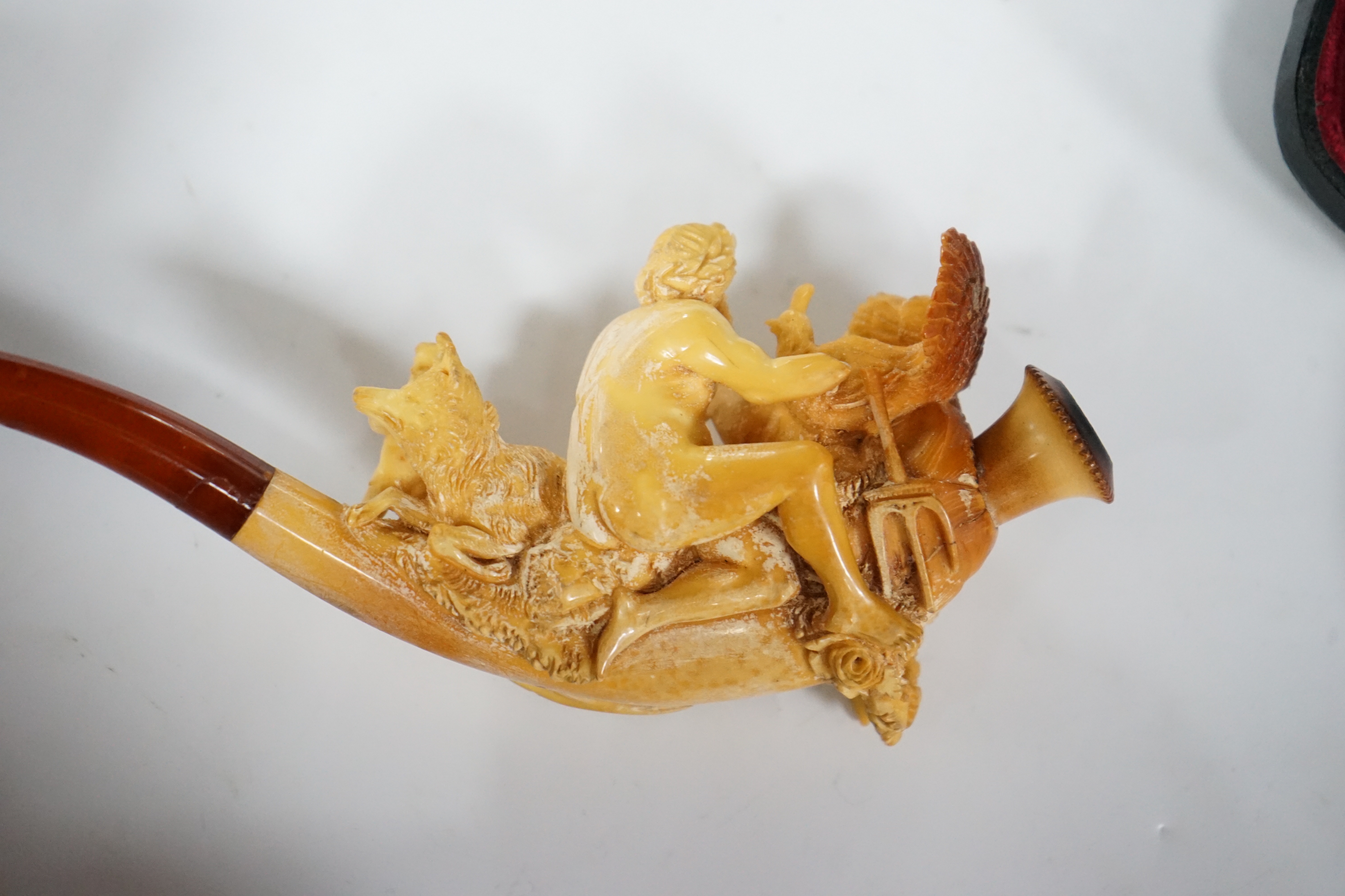 A cased ornate Meerschaum pipe, early 20th century, intricately carved with the figures of Mars and Rhea Silvia with Romulus and Remus and the wolf on the bowl, 18cm long